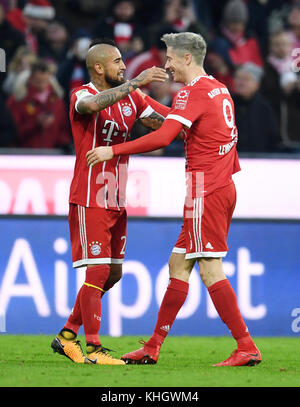 Die Münchner Arturo Vidal und Robert Lewandowski (R) bejubeln den Spielstand 2-0 während des Bundesliga-Fußballspiels zwischen Bayern München und dem FC Augsburg in der Allianz Arena in München am 18. November 2017. (EMBARGO-BEDINGUNGEN - ACHTUNG: Aufgrund der Akkreditierungsrichtlinien erlaubt die DFL nur die Veröffentlichung und Nutzung von bis zu 15 Bildern pro Spiel im Internet und in Online-Medien während des Spiels.) Foto: Tobias Hase/dpa Stockfoto