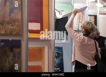 Frankfurt am Main, Deutschland. Oktober 2017. Ein Besucher, der einen Kalender in der Kalendergalerie der Buchmesse in Frankfurt am Main durchblättert, 13. Oktober 2017. Quelle: Fabian Sommer/dpa/Alamy Live News Stockfoto