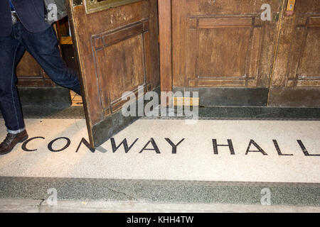 Die Menschen verlassen durch den Haupteingang zu Conway Hall, der ethischen Gesellschaft der 1920er Jahre das Hauptquartier von Red Lion Square, London WC1, UK Stockfoto