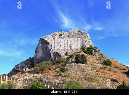 Höhepunkt Rock auf einem Hügel mit Büschen bewachsene Stockfoto