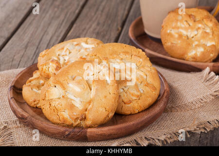 Nahaufnahme von weißer Schokolade Macadamianuss Cookies auf einer Holzplatte Stockfoto