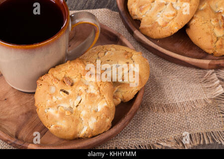 Weiße Schokolade Macadamianuss Cookies und Kaffee Stockfoto