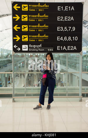 thailändische Traveler-Frauen posieren für Foto mit allgemeiner und Informationstafel im internationalen Flughafen Suvarnabhumi am 23. August 2017 in Bangko Stockfoto