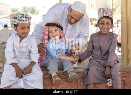 Nizwa, Oman, 10. Nobember 2017: omani Kid und Europäischen kid Hände schütteln Stockfoto