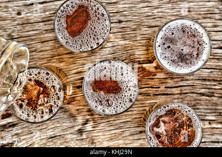 Bier zapfen. Gläser mit Bier stehen auf einem Holztisch. closeup. Blick von oben. Stockfoto