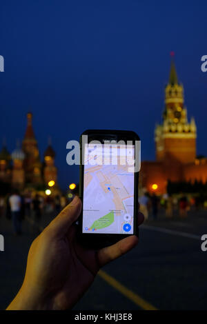 Männliche Hand, die ein Smartphone mit Google Maps App Stockfoto