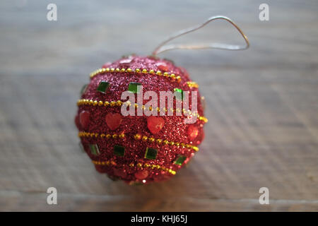 Weihnachtsbaum dekorative Weihnachtskugel rot mit Liebe im Herzen hellblau Holz- Hintergrund Stockfoto
