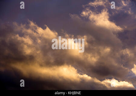 Sonnenuntergang im Herbst, der tiefe Farbe in den Wolken erzeugt, während die Sonne unter den Horizont taucht. Stockfoto