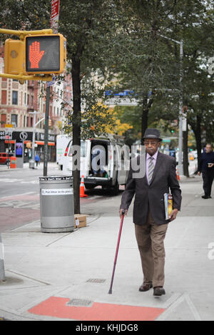 NEW YORK CITY, NY, USA - Oktober 2017 - unbekannter Mann mit einem Kane stehen und warten, bis die Leds ändern Stockfoto