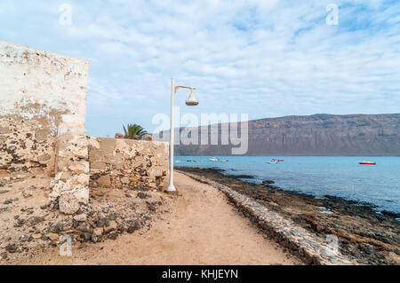 Alte Fassade in einer Straße mit Lanzarote im Hintergrund, Caleta del Sebo, La Graciosa, Kanarische Inseln, Spanien Stockfoto