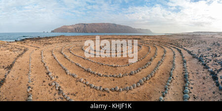 Runde Steine am Boden bildet eine Spirale, in der Nähe des Strandes, mit Lanzarote im Hintergrund, Caleta del Sebo, La Graciosa, Kanarischen Insel Stockfoto