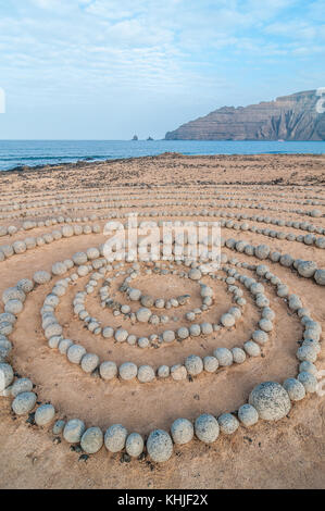 Runde Steine am Boden bildet eine Spirale, in der Nähe des Strandes, mit Lanzarote im Hintergrund, Caleta del Sebo, La Graciosa, Kanarischen Insel Stockfoto