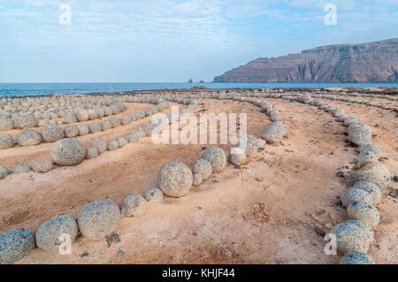 Runde Steine am Boden bildet eine Spirale, in der Nähe des Strandes, mit Lanzarote im Hintergrund, Caleta del Sebo, La Graciosa, Kanarischen Insel Stockfoto