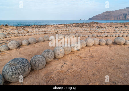 Runde Steine am Boden bildet eine Spirale, in der Nähe des Strandes, mit Lanzarote im Hintergrund, Caleta del Sebo, La Graciosa, Kanarischen Insel Stockfoto