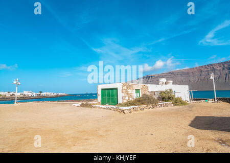 Blick auf eine typische Straße von Caleta del Sebo mit einem alten Haus im Vordergrund, La Graciosa, Kanarische Inseln, Spanien Stockfoto