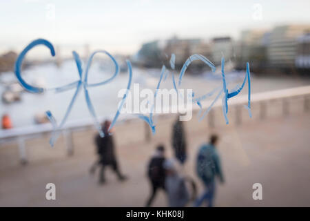 Graffiti auf dem Fenster eines London Bus und Pendler crossing London Bridge geschrieben, am 13. November 2017 in London, England. Stockfoto