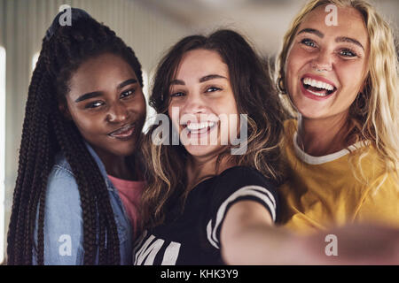 Vielfältige Gruppe von lachenden Jungen Freundinnen ein selfie zusammen und genießen Sie einen Abend zusammen Stockfoto