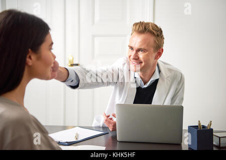 Beauty Spezialist Mensch berühren Gesicht der jungen Frau und gab ihr eine Beratung. Stockfoto