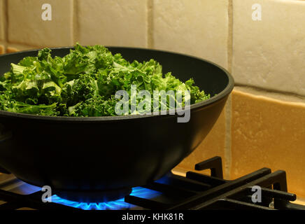 Kohl Kohl sind mit Knoblauch in einer tiefen Pfanne gekocht Pan. die Pfanne auf dem Gasherd. Stockfoto