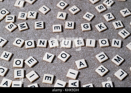 Verwirrung heraus auf scrabble Stil geschrieben beschriftete Steine unter einem Wust von anderen Buchstaben. Stockfoto