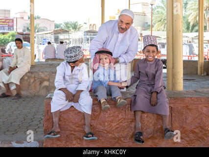 Nizwa, Oman, 10. Nobember 2017: omani Kid und Europäischen kid Hände schütteln Stockfoto