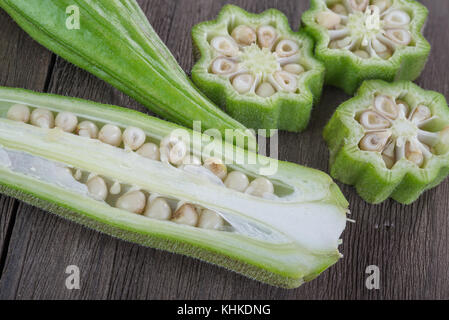 Frische Okra Gemüse auch als Lady's Finger auf alten hölzernen Hintergrund bekannt Stockfoto