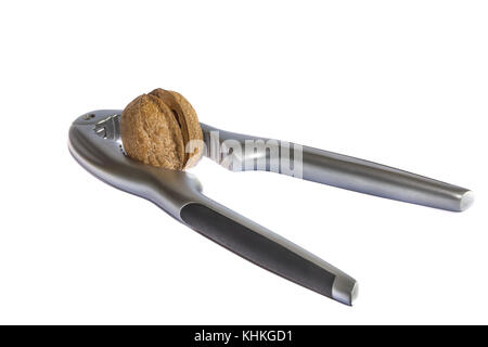 Gebrochene Nussbaum in einen Nussknacker, auf weißem Hintergrund Stockfoto