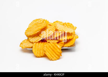 Gerippte Kartoffelchips mit Gewürzen auf weißem Hintergrund Stockfoto