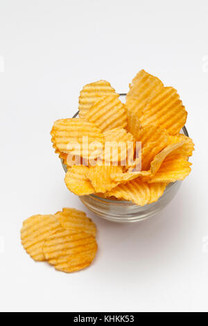 Gerippte Kartoffelchips mit Gewürzen auf weißem Hintergrund Stockfoto