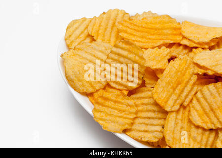 Gerippte Kartoffelchips mit Gewürzen auf weißem Hintergrund Stockfoto