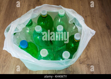 Grüne Kunststoffflaschen mit Kappen. Ökologische Trennung von Hausmüll. leere PET-Flaschen in einen Plastikbeutel. Stockfoto