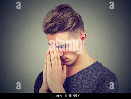 Mann traurig mit gespannten Gesichtsausdruck beten Stockfoto