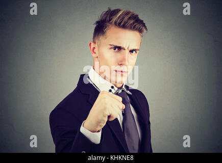 Wütend business Mann mit Faust an Kamera suchen auf grauem Hintergrund Stockfoto