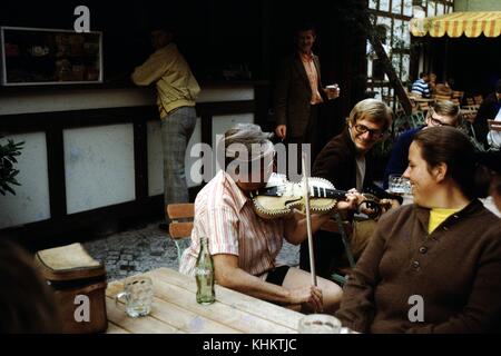 Frau spielt eine Geige in einem Café, leere Flasche Coca Cola sichtbar, Irland, 1960. Stockfoto