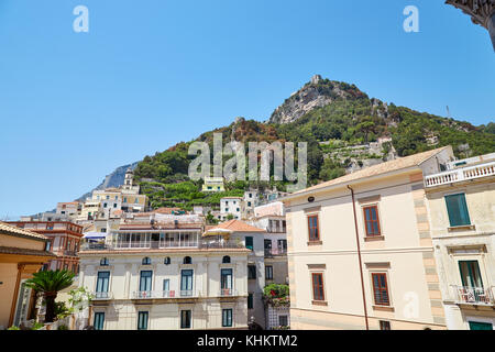 Blick auf die Stadt Amalfi von der Treppe des lokalen Duomo in einem Sommer sonnigen Tag mit Bergen im Hintergrund. Amalfi, Italien. Stockfoto