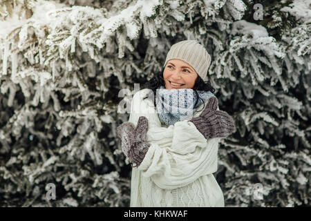 Porträt einer fröhlichen Frau sich umarmen vor der Bäume im Schnee Stockfoto