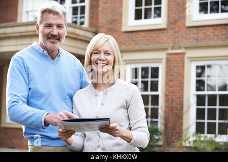 Reifes Paar stehen vor dem Haus mit Blick auf Details Stockfoto