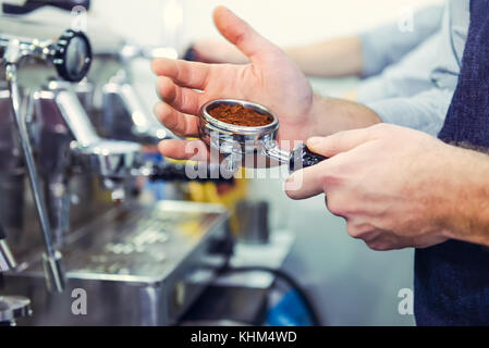 Nahaufnahme barista Kaffee mahlen, Gruppe, Vorbereiten zum Espresso erschossen. Selektive konzentrieren. Platz für Text. Stockfoto