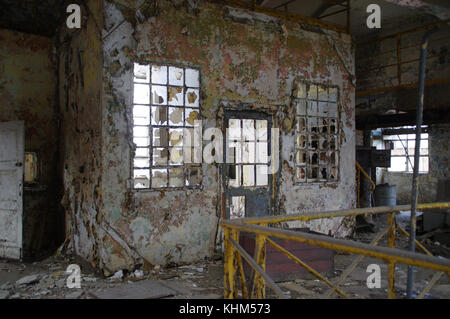 Alte auf Wand gemalt, zerbrochene Fenster, Tür zerstört. vintage Industrie- und vergessener Ort Thema. Stockfoto