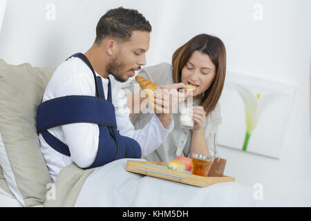 Verletzte junge Frühstück im Bett Stockfoto
