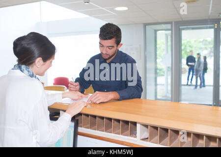 Man Einchecken an der Rezeption Stockfoto