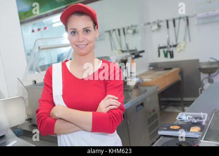 Fröhliche Frau Metzger auf Supermarkt Stockfoto