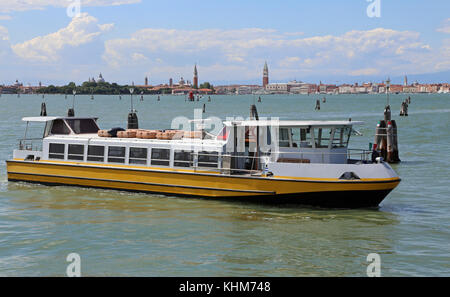 Gelbe Fähre navigiert schnell auf der venezianischen Lagune während des Transports der Touristen auf der Insel von Venedig in Italien Stockfoto