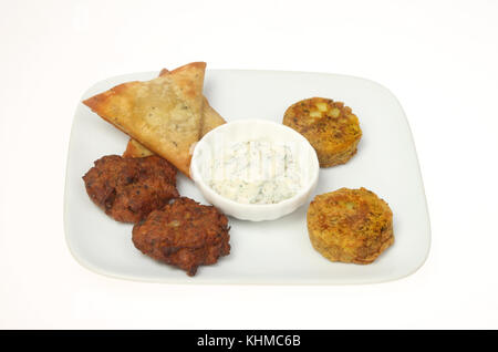 Indische snack Auswahl mit einem Sprung auf eine Platte gegen Weiße isoliert Stockfoto