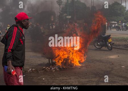 Nairobi, Nairobi County, Kenia. November 2017. Brennende Straßenbarrikade, die während des Protestes beobachtet wurde, als Menschen in der Nähe vorbeigehen. Quelle: Jan Husar/SOPA/ZUMA Wire/Alamy Live News Stockfoto