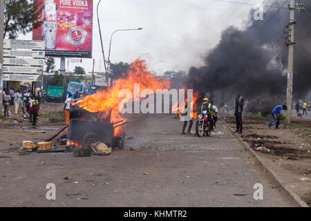 Nairobi, Nairobi County, Kenia. November 2017. Brennende Straßenbarrikade, die während des Protestes beobachtet wurde, als Menschen in der Nähe vorbeigehen. Quelle: Jan Husar/SOPA/ZUMA Wire/Alamy Live News Stockfoto