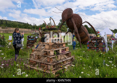 Mom fotos Kind durch umweltfreundliche Bug Hotel wettbewerbsbeiträge und riesigen Biene Skulptur - RHS Chatsworth House, Flower Show, Derbyshire, England, UK. Stockfoto