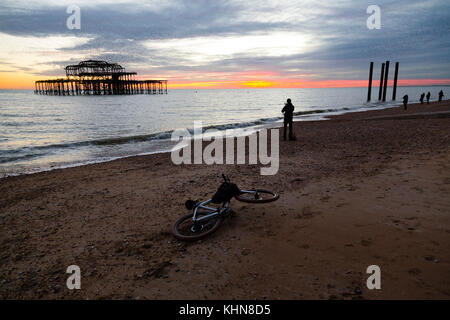 Brighton, UK. Ein Fahrrad ist auf den Boden gefallen wie seine Besitzer aus zu fotografieren, eine spektakuläre Starling murmuration über Brighton's aufgegebenen West nimmt Stockfoto