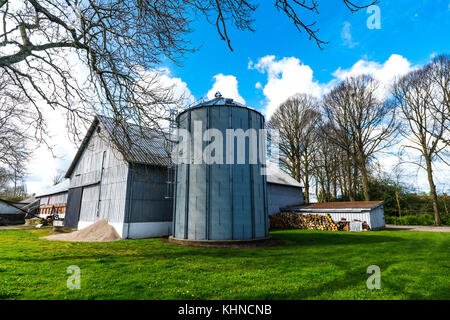 Kleiner Bauernhof mit einem grossen Silo in einer ländlichen Umgebung in den Frühling Stockfoto