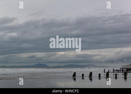 Blick Meer auf den Lynn Halbinsel von tywyn Strand mit buhnen am Strand im Vordergrund. Stockfoto